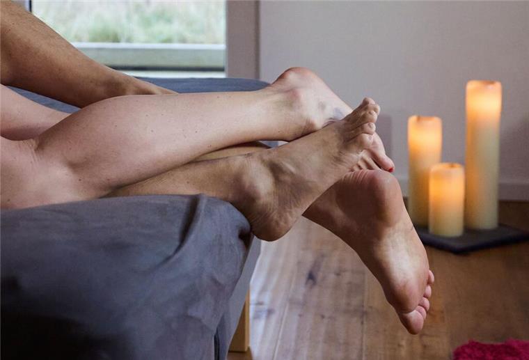 Affäre am Arbeitsplatz: Was erlaubt ist – und wo Grenzen liegen Eine Frau und ein Mann liegen eng umschlungen in einem Bett.