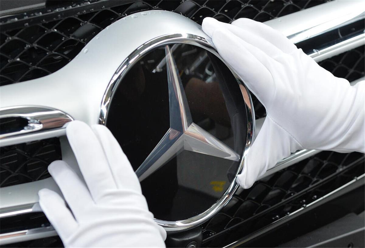 Kurzarbeit im Bremer Mercedes-Werk Ein Mitarbeiter von Mercedes-Benz bringt im Werk in Bremen den Stern an