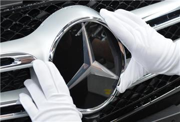 Ein Mitarbeiter von Mercedes-Benz bringt im Werk in Bremen den Stern an 