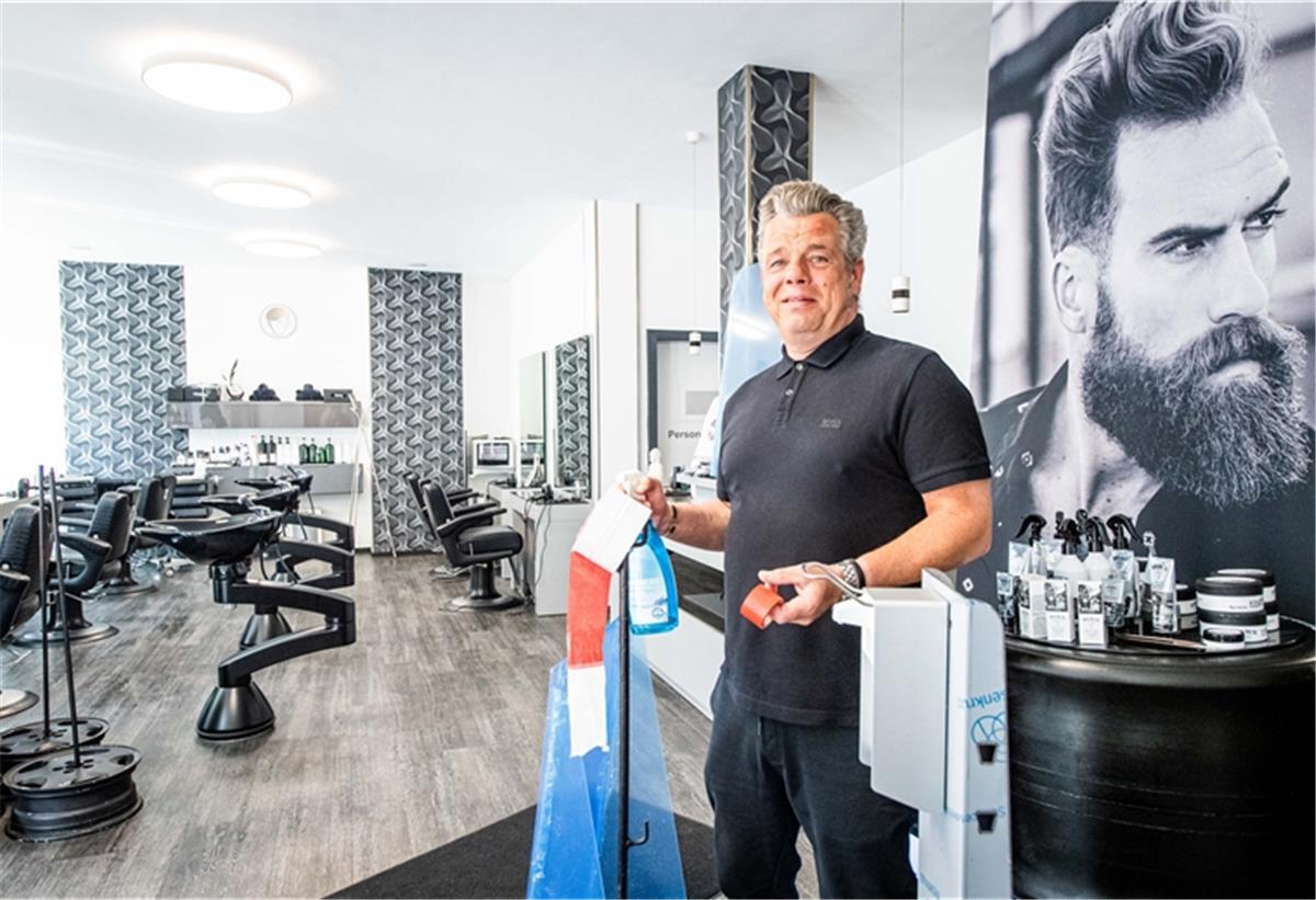 Lokale Friseurstudios bereiten sich mit Hygienemaßnahmen auf ihre Kundschaft für die Wiederöffnung ihrer Läden ab 4. Mai vor. Andre Albers, Inhaber des Frisörsalons "Hauptsache" in der Bremerhavener Georgstraße, bereitet seinen Salon mit Absperrband, Desinfektionsmittelspender und Bodenleitlinien auf den Kundenansturm vor. Foto: Hartmann