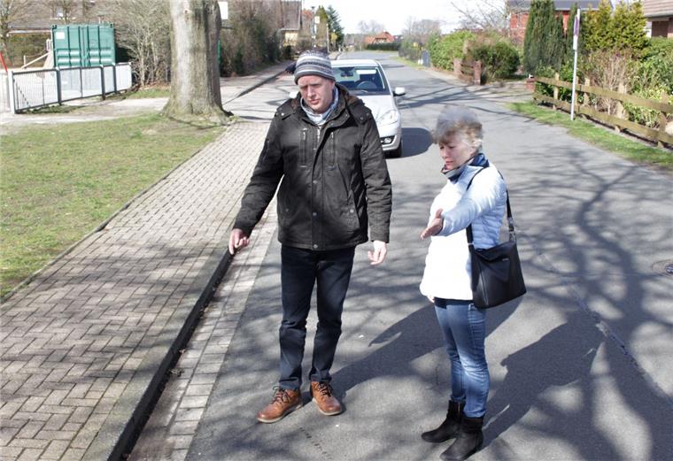 Lüder Schnibbe und Gabriele Hielscher sehen sich die Situation vor der Bramstedter Grundschule an. Die Fläche auf der Straße soll als Sperrfläche gekennzeichnet werden.