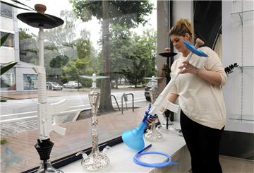 Madeline Brunks hält eine der Wasserpfeifen in Kalaschnikow-Form fest, die sie in ihrem Shisha-Laden verkauft.