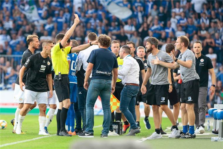 Magdeburgs Co-Trainer Silvio Bankert (rechts, mit den blauen Socken) bekam eine der neuen Regeln als Erster zu spüren. Er bekam im Drittligaspiel gegen Eintracht Braunschweig von Schiedsrichter Felix Zwayer die Rote Karte gezeigt. Das war bisher nicht möglich. 