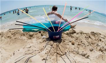 Ein Eimer mit Strohhalmen steht am Strand von Arenal auf Mallorca.