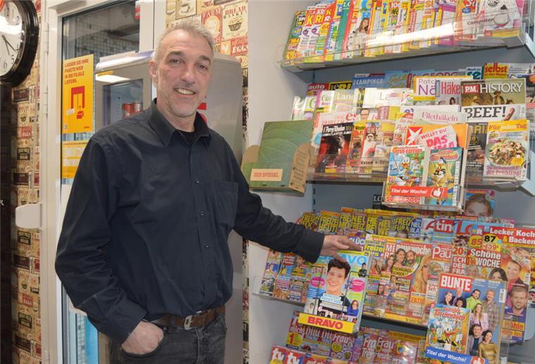 Ein Mann steht vor einem Magazin-Regal