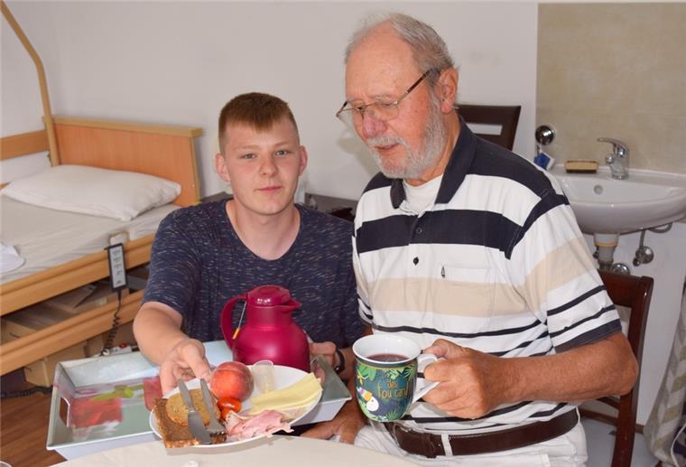 Marcel Tittel (links) bringt Manfred Lange das Abendessen. Der Auszubildende in der Altenpflege serviert neben der Mahlzeit aber auch Zuwendung und Herzenswärme.