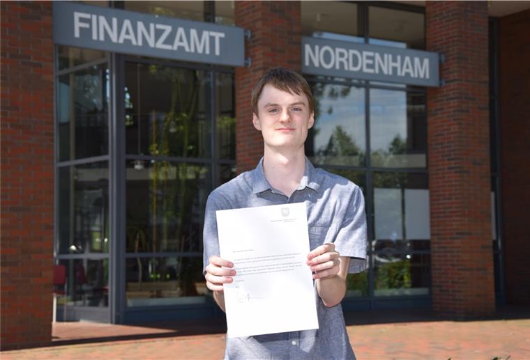 Marco Peters hält das Glückwunschschreiben des niedersächsischen Finanzminsters Reinhold Hilbers in den Händen. Das hat er aufgrund seines besonders guten Abschlusses zum Diplom-Finanzwirt erhalten.