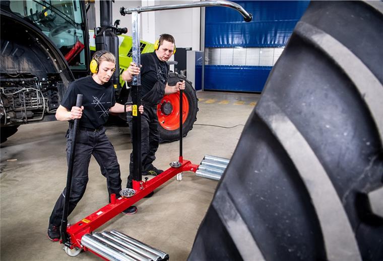 Mariam Suhk (l.) und Menko Lottmann wechseln das Hinterrad von einem Traktor. Mit 3 Minuten und 16 Sekunden haben die beiden Schrauber einen neuen Weltrekord aufgestellt.