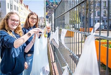 Marie Speckmann (links) und Rieke Klemm, hängen Lebensmittel an den Gabenzaun für Bedürftige.