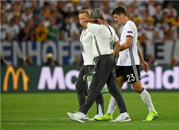 Mario Gomez wird von Mannschaftsarzt Hans-Wilhelm Müller-Wohlfahrt vom Feld geführt.