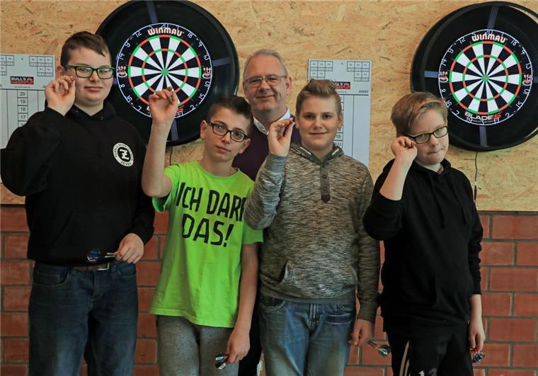Mark Borkenhagen, Abteilungsleiter für Darts des TuS Zeven (Mitte), hat bei Milan Eberhardt, Luca Haase, Raul Dordea, Felix Oetjen (von links) die Faszination für den Präzisionssport schon in den ersten drei Wochen des neuen Ganztagsangebotes geweckt.