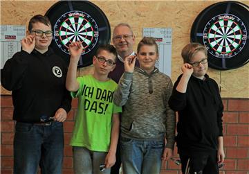Mark Borkenhagen, Abteilungsleiter für Darts des TuS Zeven (Mitte), hat bei Milan Eberhardt, Luca Haase, Raul Dordea, Felix Oetjen (von links) die Faszination für den Präzisionssport schon in den ersten drei Wochen des neuen Ganztagsangebotes geweckt.