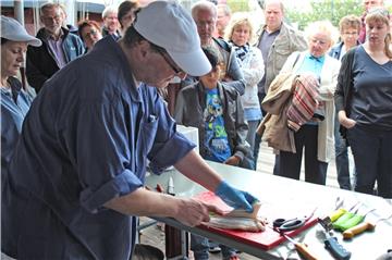 Martin Sander zeigt den Besuchern der Fischparty, wie Fisch filetiert wird. 