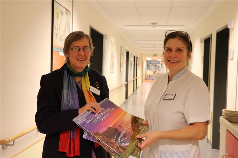 Martina Scholz-Mehrtens (links) verteilt schöne Mutmacher-Kalender mit irischen Segenswünschen auf der Station. Sie sind für die Patientenzimmer gedacht. Heike Dudkin nimmt sie auf der Urologie entgegen.  Foto Albert