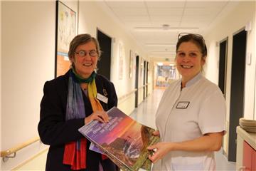 Martina Scholz-Mehrtens (links) verteilt schöne Mutmacher-Kalender mit irischen Segenswünschen auf der Station. Sie sind für die Patientenzimmer gedacht. Heike Dudkin nimmt sie auf der Urologie entgegen.  Foto Albert