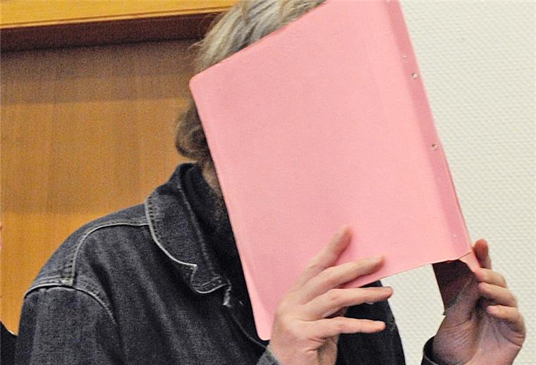 Der wegen dreifachen Kindermordes angeklagte Martin N. verdeckt am Montag (27.02.2012) im Landgericht in Stade vor der Urteilsverkündung im Prozess gegen ihn sein Gesicht hinter einem Aktendeckel.