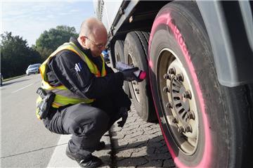 Matthias Clemens von der Polizei Bremerhaven markiert einen Lkw-Reifen. Der hat so starke Risse, dass sogar das Stahlgerippe zum Vorschein kommt.