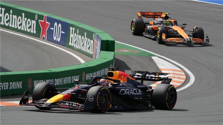 Max Verstappen (l) überholt Lando Norris am Start.