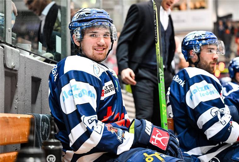 Ein Eishockey-Spieler sitzt auf einer Bank.