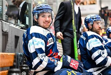 Ein Eishockey-Spieler sitzt auf einer Bank.