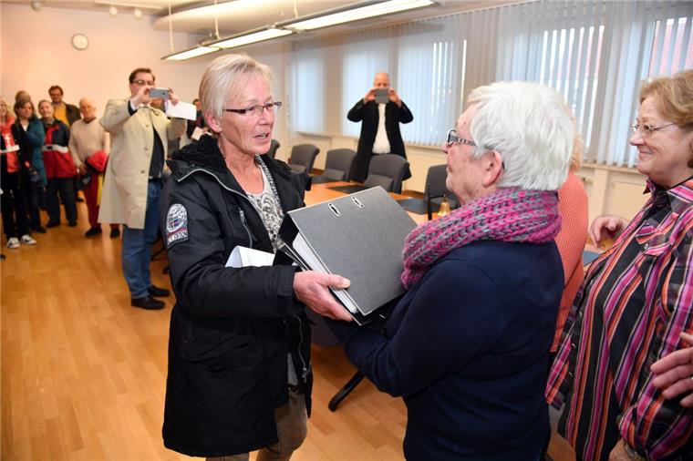 Meergestrüpp-Mitglied Irene Sander (links) überreicht zwei volle Ordner mit Unterschriften an die Stadtverordnetenvorsteherin Brigitte Lückert. Die Unterschriften stammen von Gegnern der Bebauungspläne im Gebiet der Neuen Aue.