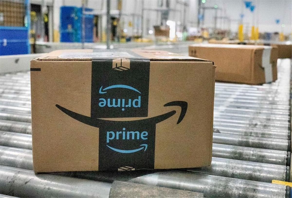 Mehrere Amazon-Pakete liegen auf einem Fließband. Amazon investiert kräftig und schafft neue Jobs in Deutschland. 