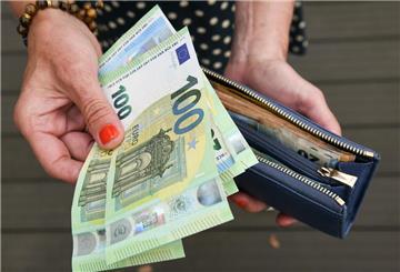 Eine Frau hält eine mit mehreren Geldscheinen gefüllte Geldbörse in einer Hand. Für Familien mit Kindern soll es künftig mehr Geld geben.