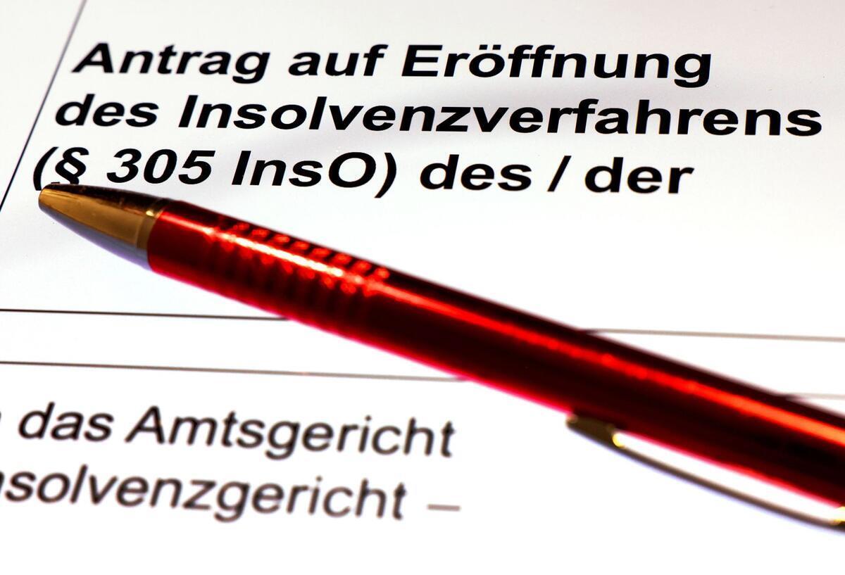 Ein Kugelschreiber liegt auf dem Formular für einen Insolvenzantrag.