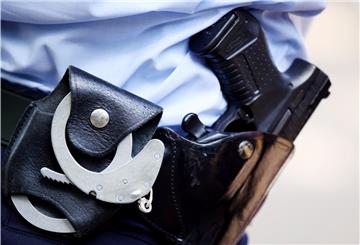 Der Gürtel einer Polizistin mit Handschellen und Pistole.  