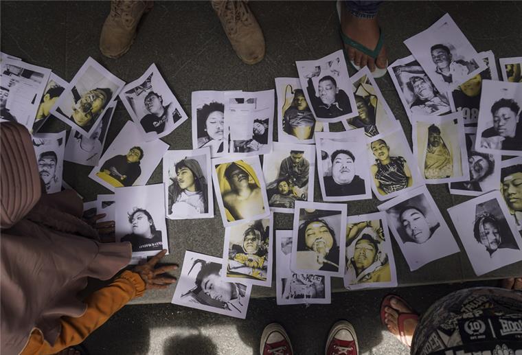 Mindestens 174 Tote bei Massenpanik in Indonesien Menschen, die nach ihren Angehörigen suchen, betrachten Fotos von Opfern der Fußballkrawalle, die ihnen von Freiwilligen zur Verfügung gestellt wurden, um ihnen bei der Identifizierung ihrer Familienangehörigen zu helfen.