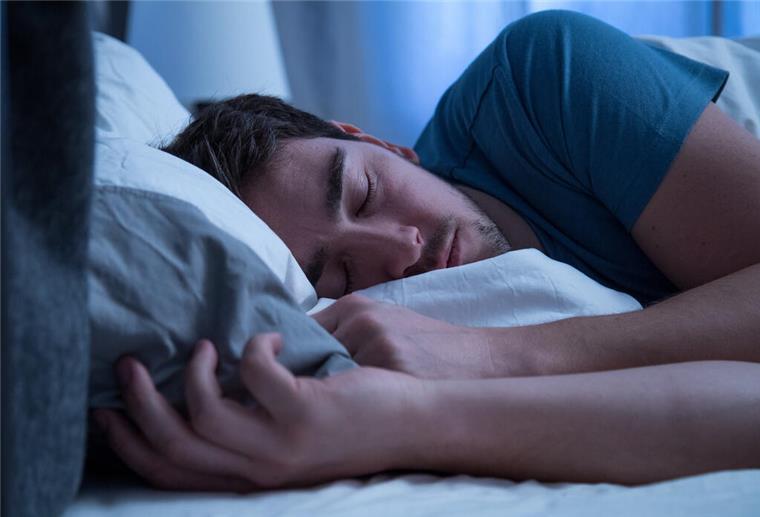 Schlafmangel macht anfälliger für Verschwörungstheorien Ein Mann schläft seitlich im Bett