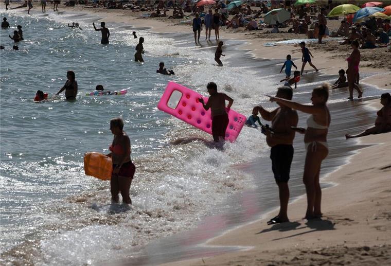  Menschen genießen das sonnige Wetter am Strand von Magaluf auf Mallorca