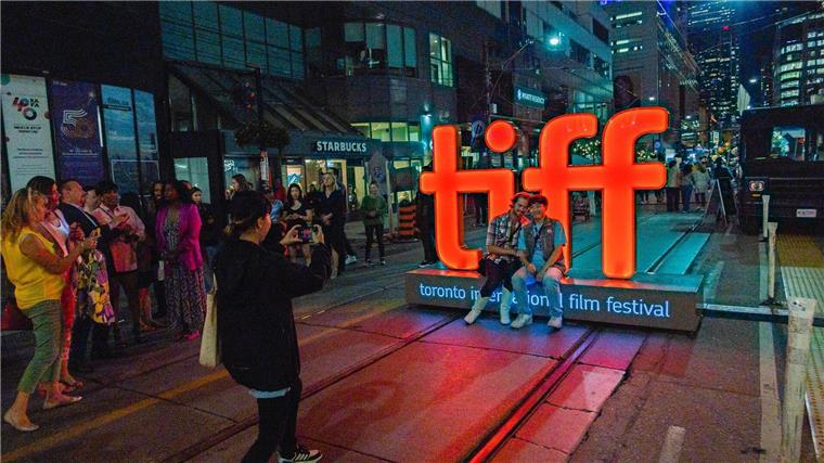 „American Fiction“ gewinnt beim Filmfest in Toronto Menschen machen Fotos vor einer Leuchtreklame vor der TIFF Bell Lightbox während des 48. Toronto International Film Festivals.