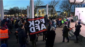 Menschen stehen bei einer Kundgebung bei einer Demonstration gegen rechts.