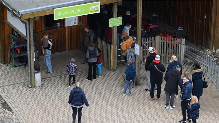 Menschen stehen für eine Fahrt mit der Sommerrodelbahn Bocksbergbob in Hahnenklee.