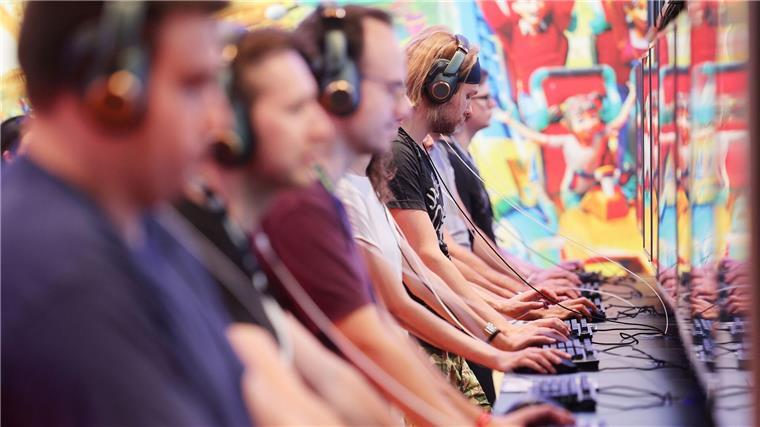 Messebesucher der Computer- und Videospielemesse „Gamescom“ testen ein Computerspiel.