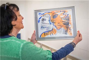 „Microsoft spioniert im Büro“: Diese Zeitungsschlagzeile leuchtet in der Collage der Bremer Künstlerin Karin Friedrichs durch ein blauäugiges Gesicht – als kritische Anfrage an die moderne Technikgläubigkeit.