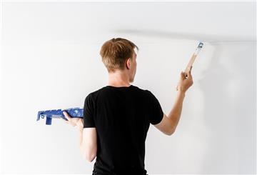 Mann streicht Wand