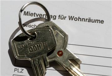  Ein Wohnungsschlüssel liegt auf einem Mietvertrag für eine Wohnung. 