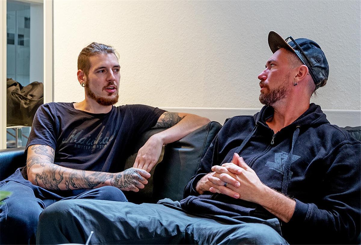 Maerzfeld: Herzensprojekt dreier Stahlzeit-Musiker zwei tätowierte Männer auf Sofa
