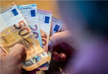  Ein älterer Mann zählt Geld an einem Tisch. 