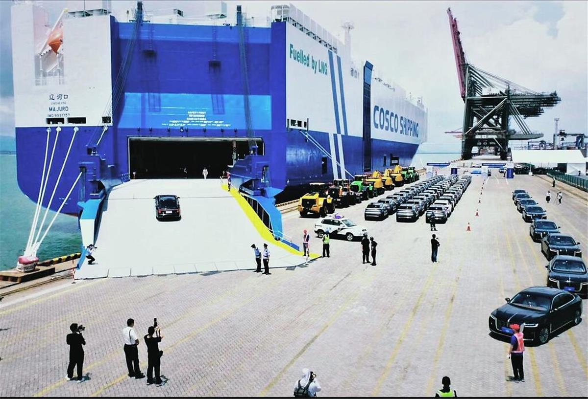Über 5400 E-Autos an Bord! Chinesischer Mega-Frachter nimmt Kurs auf Bremerhaven Mehrere Reihen von Automobilien und Fahrzeugen warten an einer Kaje darauf, an Bord des Autofrachters "Liao He Kou" zu fahren.