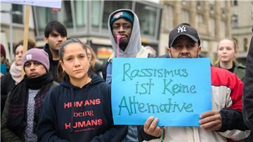 Mit beschrifteten Kleidungsstücken und Schildern demonstrieren Menschen bei einer Veranstaltung am Kröpke.