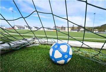 Ein Fußball liegt in einem Tor auf dem leeren Fußballplatz