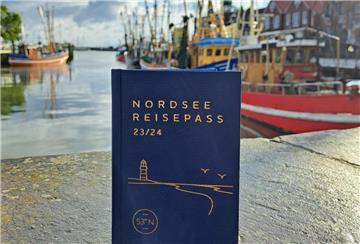 Der blaue Nordsee-Reisepass vor der Nordsee.