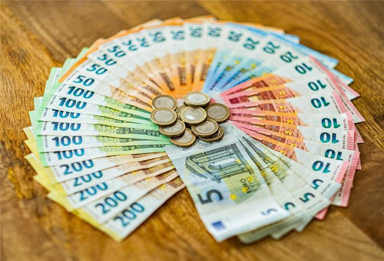 Münzen und Geldscheine liegen aufgefächert auf einem Tisch. Mit der Aktivrente sollen Rentner bis zu 24.000 Euro pro Jahr steuerfrei verdienen können – sofern sie beschließen, weiterzuarbeiten.