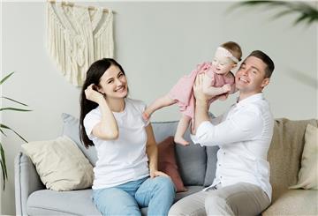 Paar sitzt mit Baby auf dem Sofa