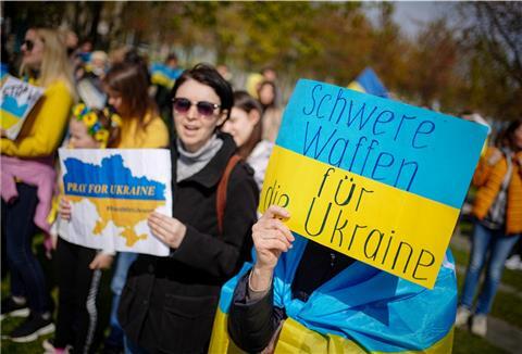 Menschen aus der Ukraine demonstrieren vor dem Bundeskanzleramt gegen den Krieg in ihrer Heimat und fordern auf Transparenten die Lieferung schwerer Waffen.