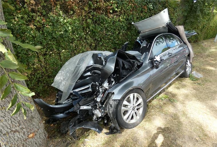Ein zerstörtes Auto liegt am Straßenrand.