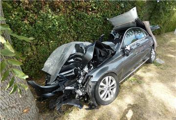 Ein zerstörtes Auto liegt am Straßenrand.